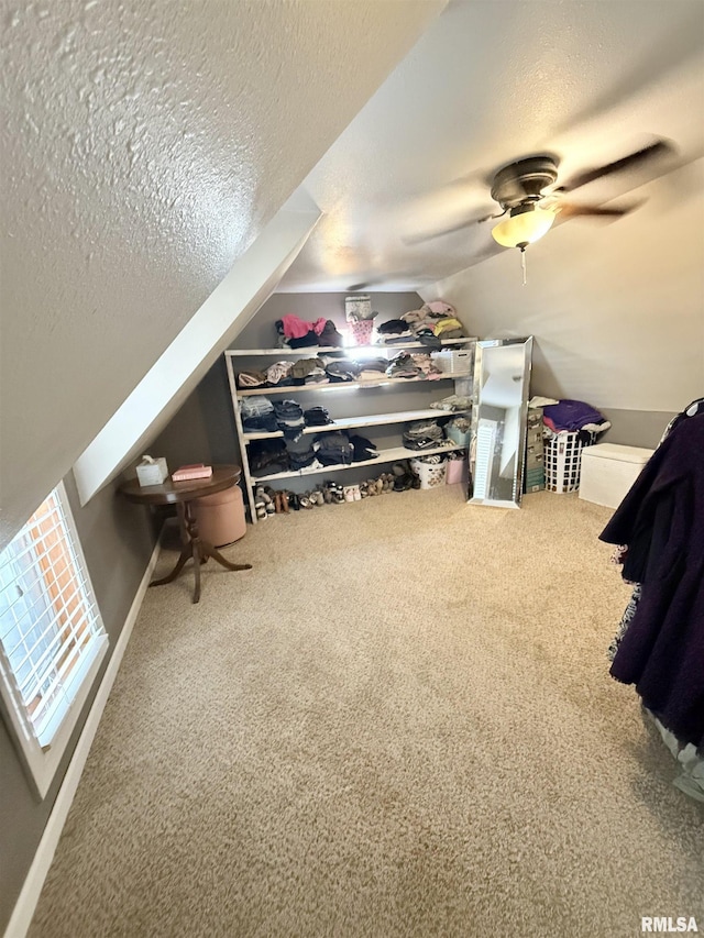 bonus room with lofted ceiling, carpet flooring, a ceiling fan, and a textured ceiling