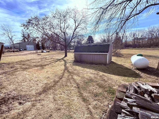 view of yard featuring an outbuilding, a storage unit, and a garage