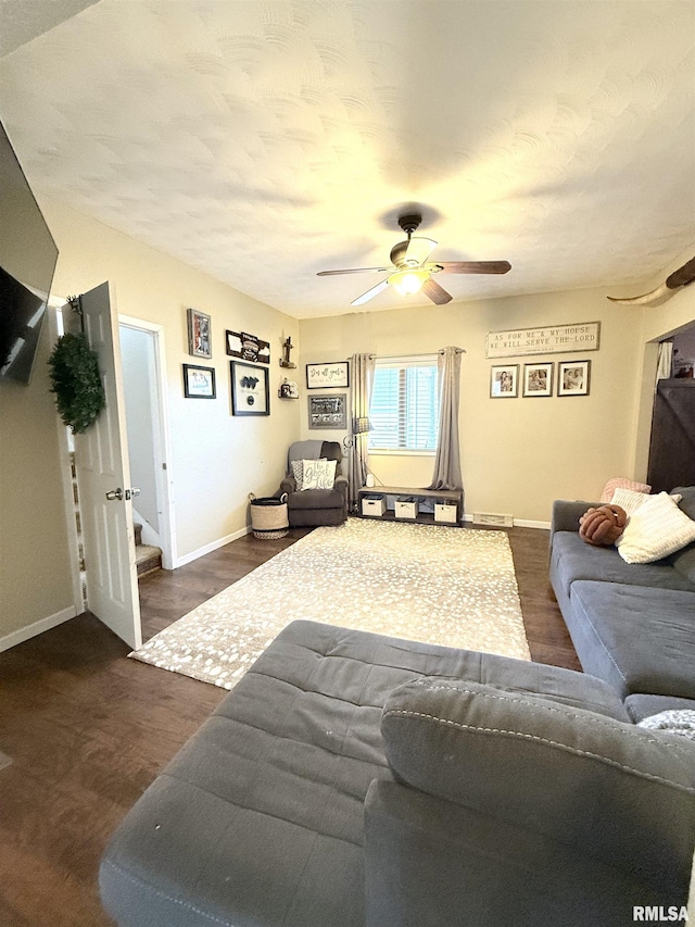 living area with baseboards, wood finished floors, and a ceiling fan