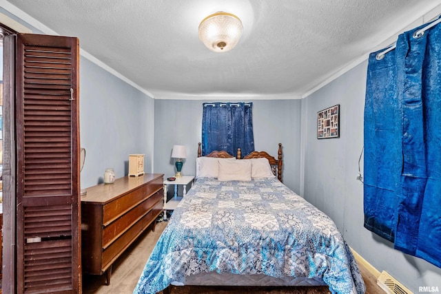 bedroom featuring visible vents, a textured ceiling, and crown molding