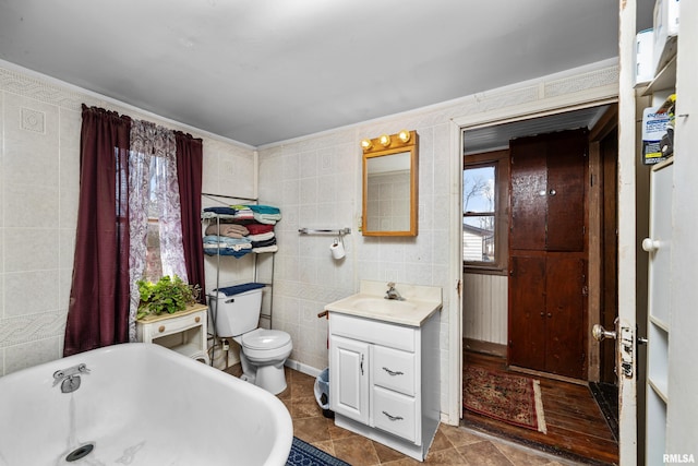 bathroom with vanity, toilet, tile walls, and a freestanding bath