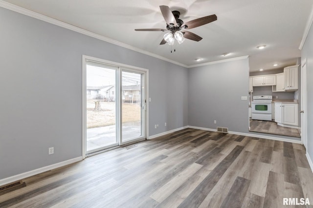 unfurnished living room with visible vents, baseboards, wood finished floors, and ornamental molding