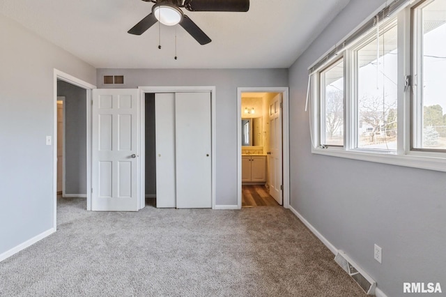 unfurnished bedroom featuring carpet floors, baseboards, visible vents, and a closet