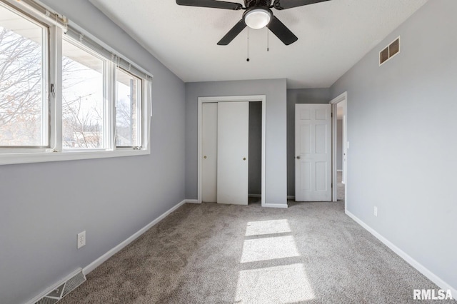 unfurnished bedroom featuring a closet, carpet flooring, visible vents, and baseboards