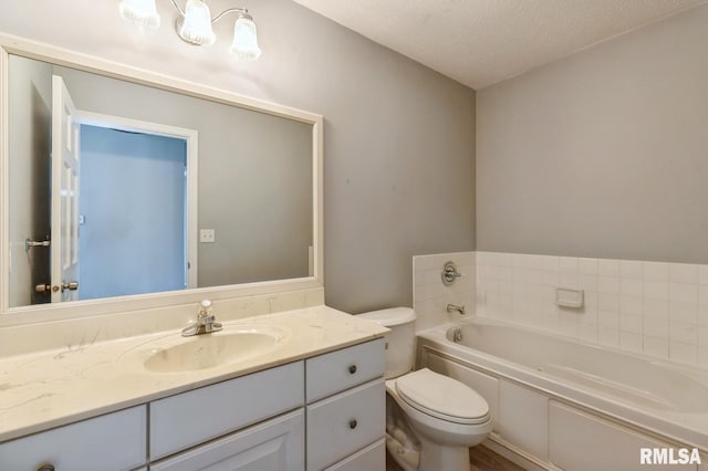 bathroom featuring toilet, a textured ceiling, a bath, and vanity