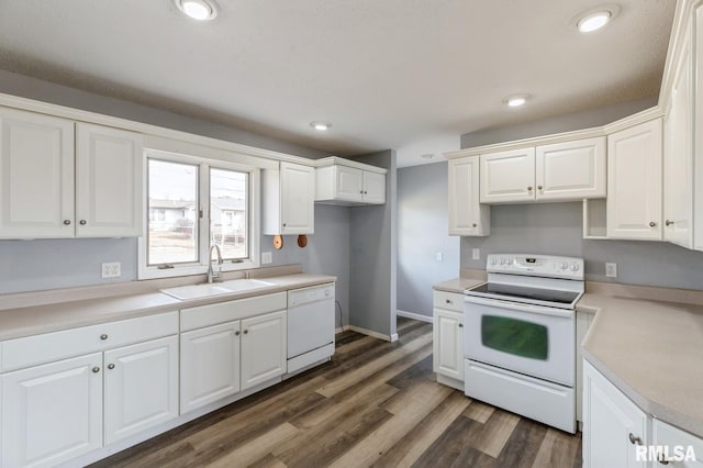 kitchen featuring white appliances, dark wood finished floors, light countertops, white cabinetry, and a sink