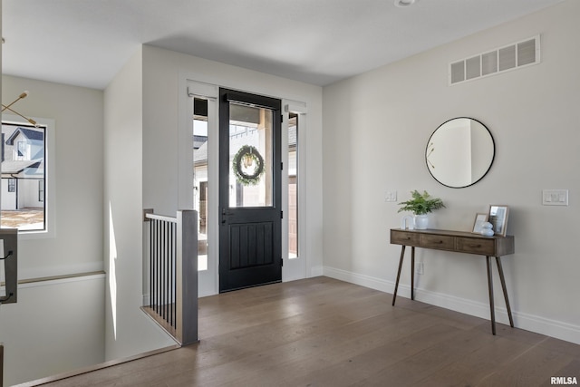 entryway with wood finished floors, visible vents, and baseboards