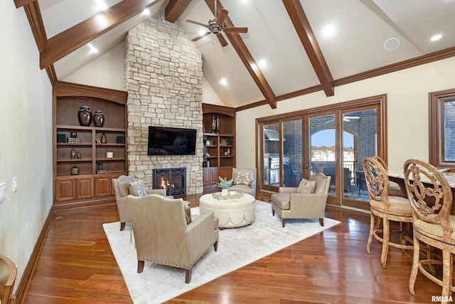 living area with beam ceiling, dark wood finished floors, a fireplace, ceiling fan, and high vaulted ceiling