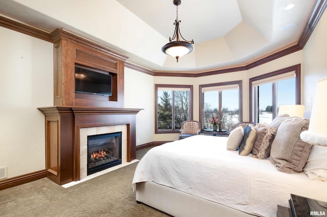 carpeted bedroom featuring baseboards, multiple windows, crown molding, and a tiled fireplace