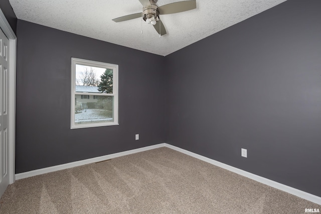 unfurnished room with carpet, baseboards, ceiling fan, and a textured ceiling