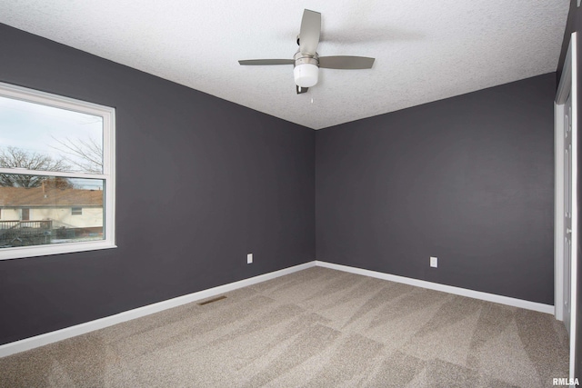 spare room with carpet, visible vents, and baseboards