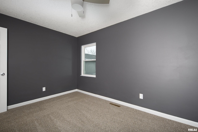 empty room featuring ceiling fan, a textured ceiling, baseboards, and carpet flooring