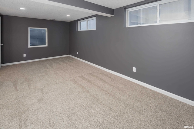 basement featuring recessed lighting, carpet flooring, a textured ceiling, and baseboards