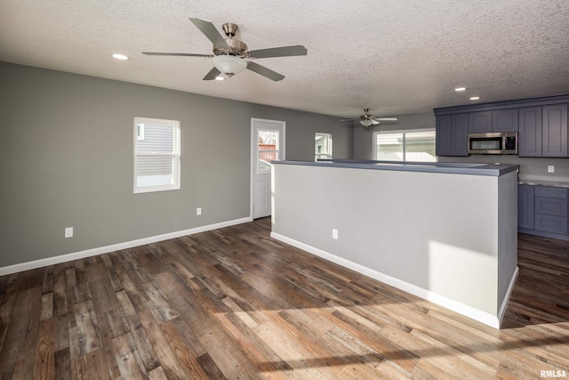 interior space featuring dark wood-style floors, stainless steel microwave, and a wealth of natural light