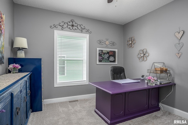 office space with a ceiling fan, light colored carpet, and baseboards