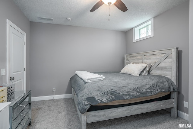 bedroom featuring a textured ceiling, carpet, visible vents, and baseboards