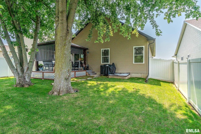 rear view of property featuring a fenced backyard, a lawn, and a wooden deck