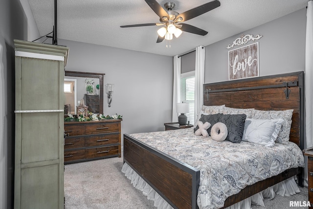 carpeted bedroom featuring a textured ceiling and a ceiling fan