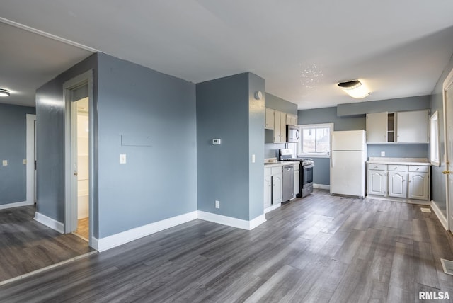 kitchen with baseboards, stainless steel appliances, dark wood finished floors, and light countertops