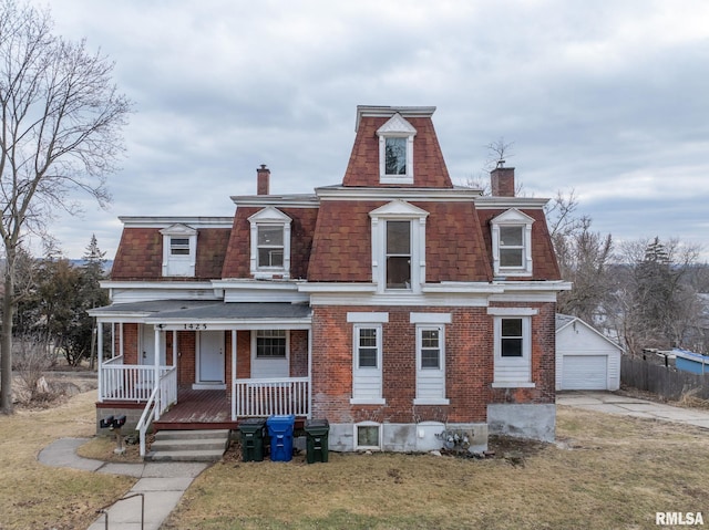 second empire-style home featuring covered porch, mansard roof, and brick siding