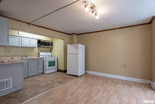 kitchen featuring white appliances, visible vents, light wood-style flooring, light countertops, and crown molding