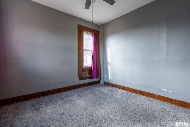 carpeted empty room with visible vents, ceiling fan, and baseboards