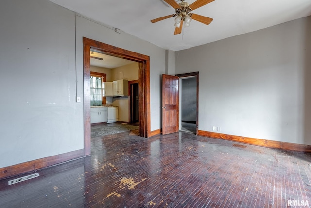 spare room with visible vents, hardwood / wood-style floors, ceiling fan, independent washer and dryer, and baseboards