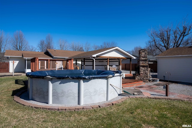 view of pool with a covered pool, a lawn, a deck, and fence