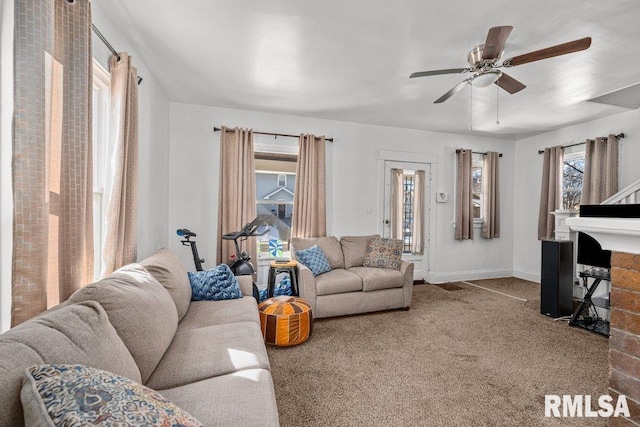 carpeted living area featuring ceiling fan, a fireplace, and baseboards