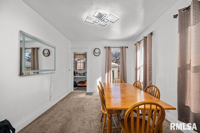 carpeted dining space featuring baseboards