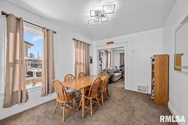 carpeted dining area featuring visible vents and baseboards