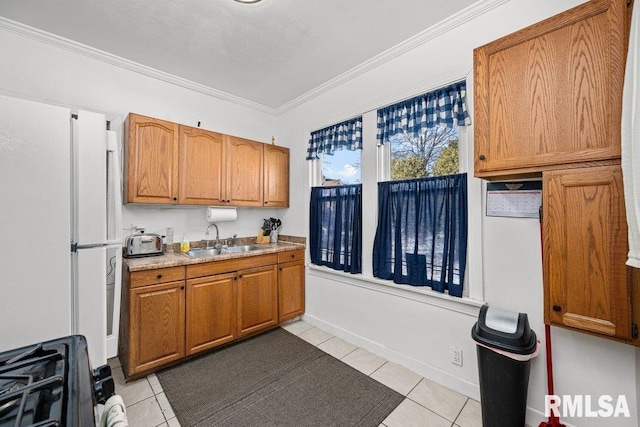 kitchen featuring ornamental molding, brown cabinets, a sink, and light tile patterned floors