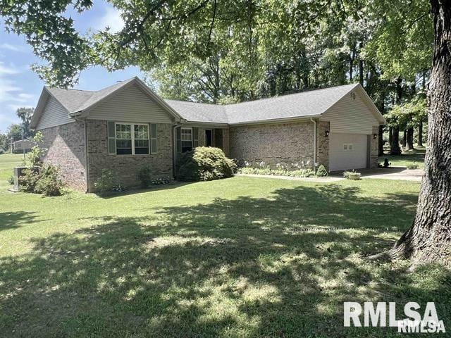 ranch-style home featuring a garage, brick siding, and a front yard