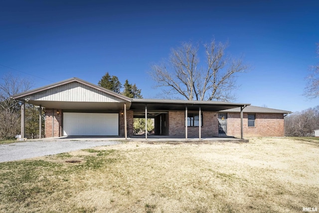 ranch-style home with a garage, brick siding, and gravel driveway