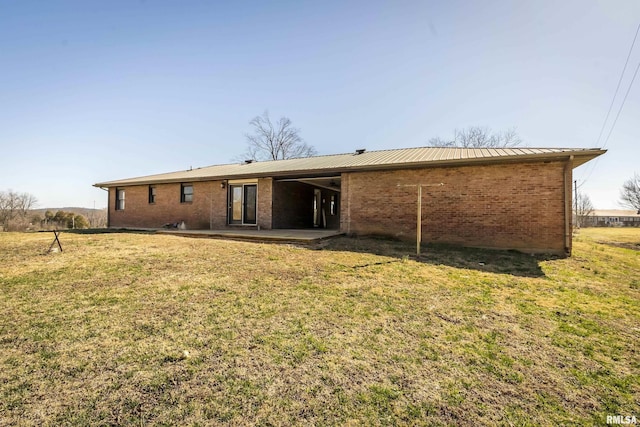 1595 Casper Church Rd, Cobden, IL 62920 - rear view of property with metal roof, a patio, brick siding, and a lawn