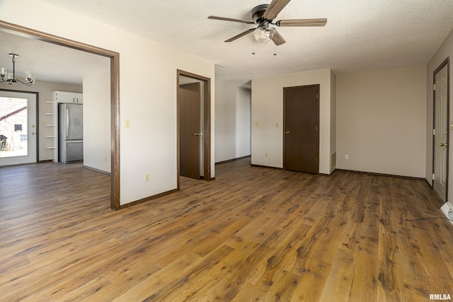 1595 Casper Church Rd, Cobden, IL 62920 - interior space featuring baseboards, a textured ceiling, hardwood / wood-style floors, and ceiling fan with notable chandelier