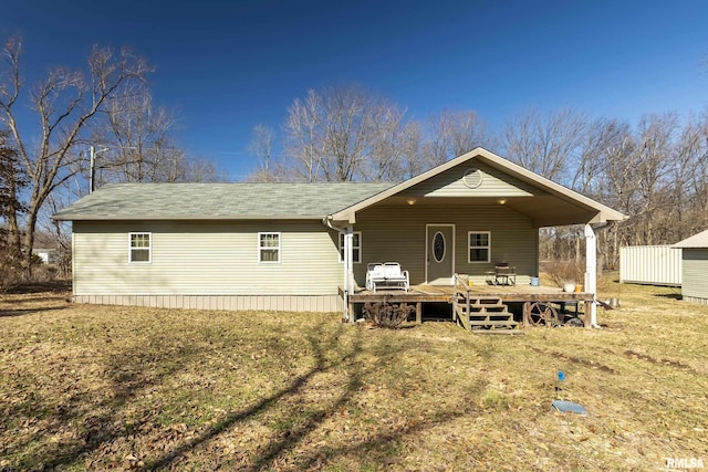 back of property featuring a deck and an outbuilding