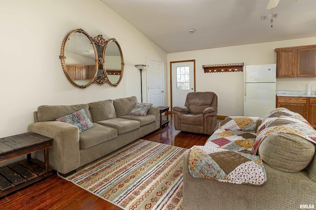 living room featuring dark wood-type flooring, visible vents, and vaulted ceiling