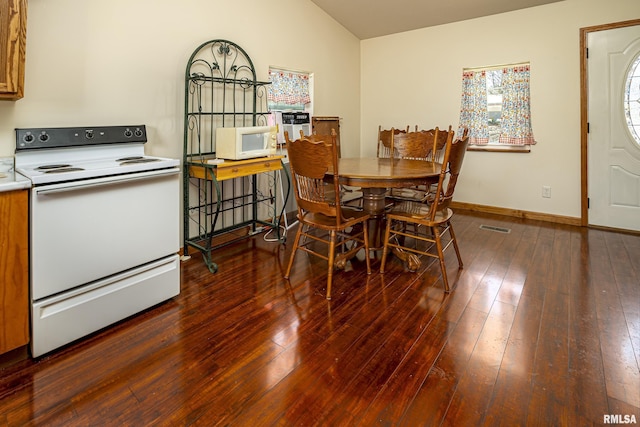 dining room with lofted ceiling, wood-type flooring, visible vents, and baseboards