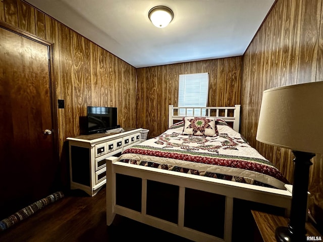 bedroom featuring wood walls and dark wood-type flooring