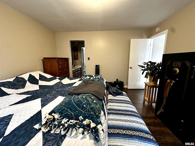 bedroom with connected bathroom and wood finished floors