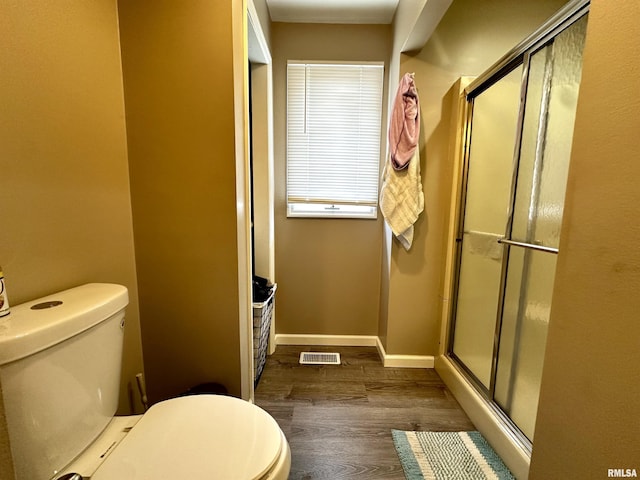 full bath with visible vents, toilet, a shower stall, wood finished floors, and baseboards