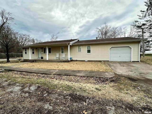 single story home with an attached garage, covered porch, and aphalt driveway