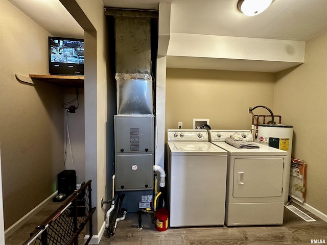 washroom with laundry area, separate washer and dryer, dark wood-type flooring, and baseboards