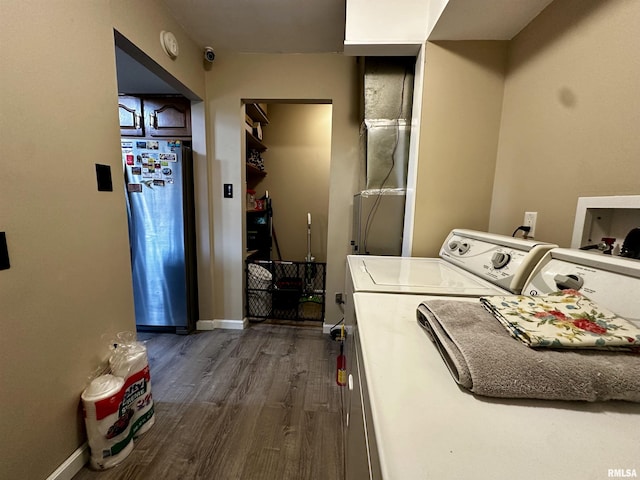 washroom with dark wood-style floors, laundry area, baseboards, and washing machine and clothes dryer