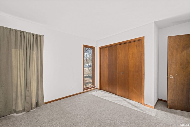 unfurnished bedroom featuring carpet, a closet, and baseboards