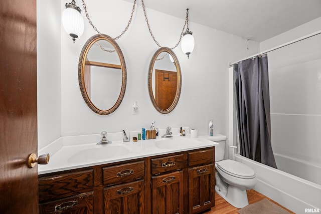 bathroom with shower / bath combo with shower curtain, a sink, toilet, and double vanity