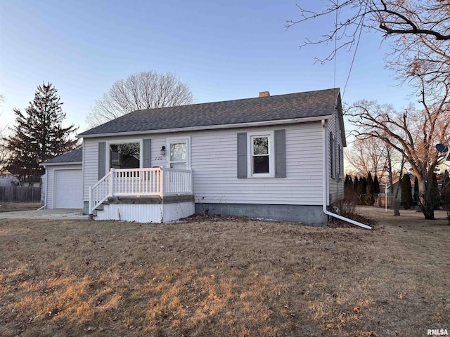 view of front of house with a garage, a chimney, a front lawn, and roof with shingles