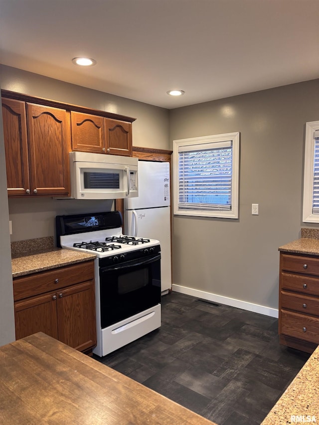 kitchen featuring white appliances, recessed lighting, and baseboards