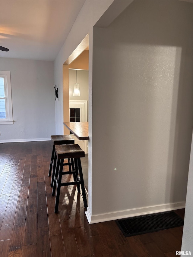 dining space featuring a ceiling fan, visible vents, dark wood finished floors, and baseboards